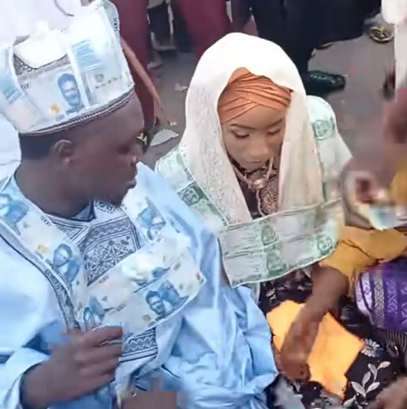 Naira Abuse: See Video Of Nigerian Couple Wearing Naira Note Necklaces At Wedding